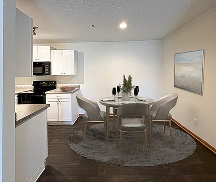 Chic dining area with modern round table set against a sleek kitchen backdrop and art-adorned wall.