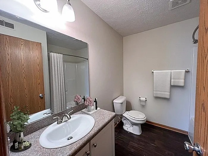 Inviting bathroom with modern fixtures, elegant lighting, and a large mirror above a sleek vanity countertop.