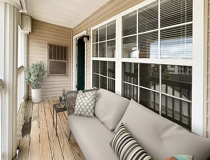 Charming sunlit patio with cozy seating, elegant decor, and large windows offering a delightful outdoor ambiance.