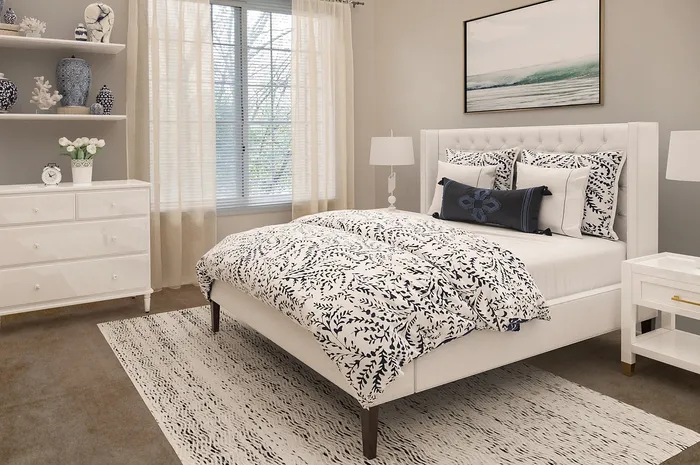 Elegant bedroom with a chic upholstered bed, intricate patterned bedding, and stylish decor, offering a tranquil and inviting atmosphere.