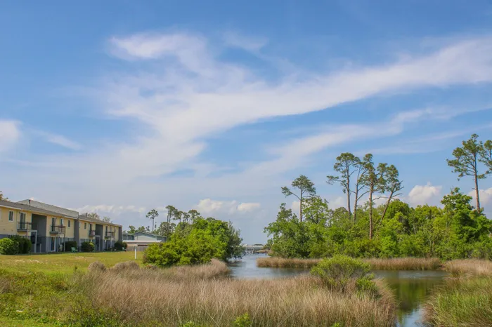Serene residential community with picturesque waterfront views and lush greenery under a clear blue sky.