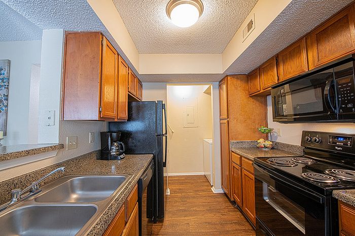 Cozy kitchen with modern appliances, sleek granite countertops, and warm wooden cabinets, perfect for home cooking.