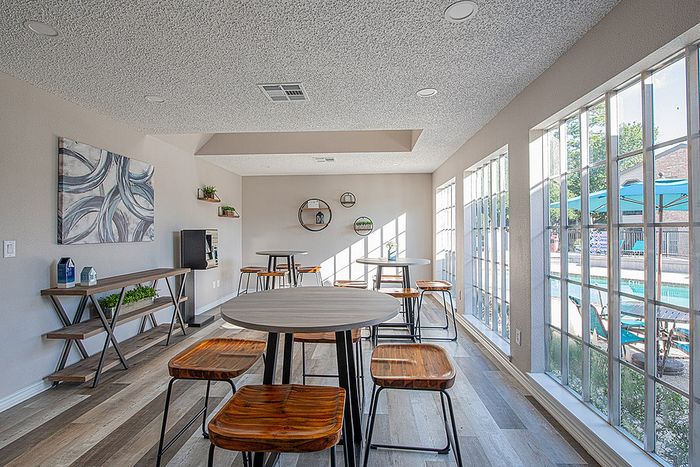 Bright and modern common area featuring stylish furniture, large windows with pool view, and contemporary decor.