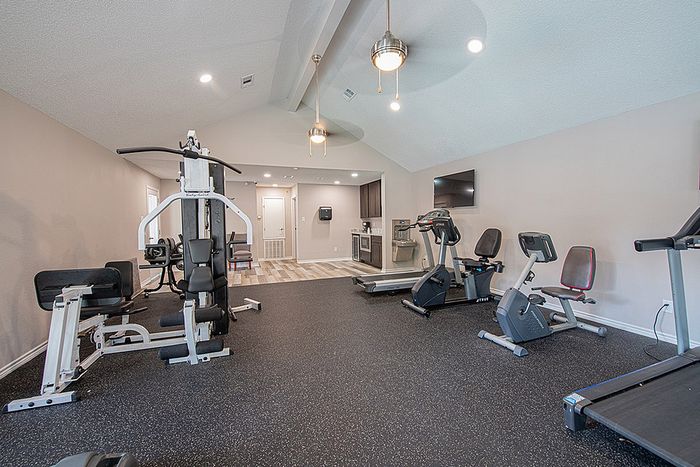 Modern apartment gym featuring high-end equipment, sleek flooring, and bright lighting for an energizing workout experience.