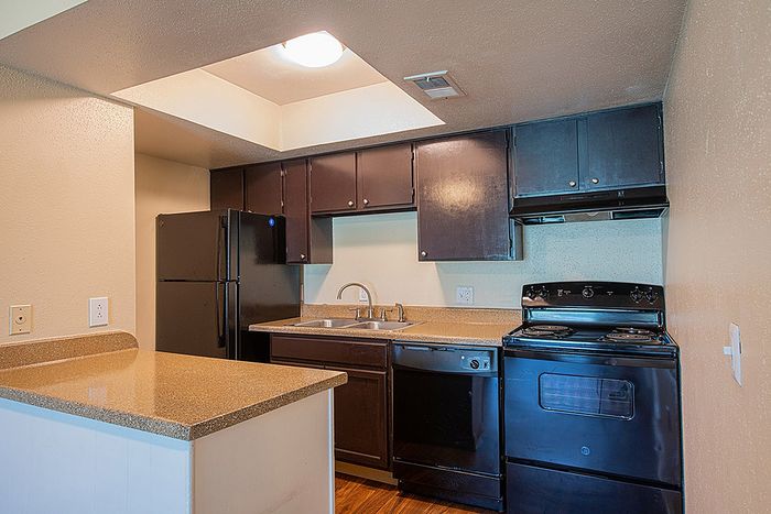 Charming kitchen with modern black appliances, sleek granite countertops, and stylish cabinets, perfect for culinary creativity.