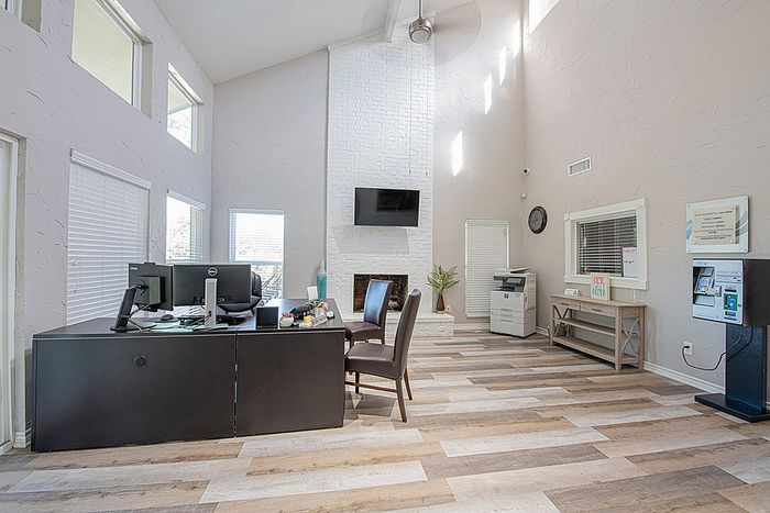 Bright and airy office space with high ceilings, stylish modern furniture, and natural wood flooring for a professional yet welcoming atmosphere.