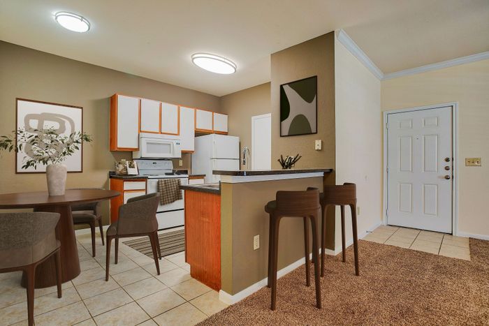 Charming open-concept kitchen and dining area with modern cabinetry, sleek countertops, and stylish bar seating.