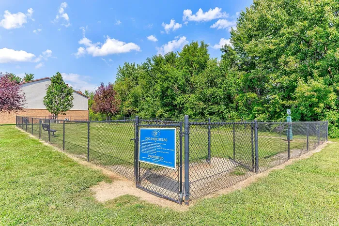 Charming fenced dog park surrounded by lush greenery, ideal for pet-friendly living.