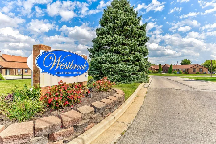 Inviting entrance to Westbrook Apartment Homes surrounded by lush landscaping and tranquil greenery.