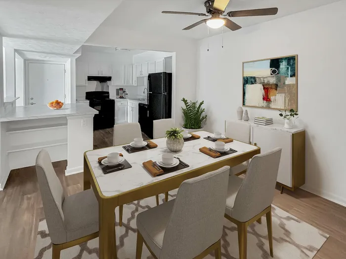 Elegant dining area with a chic marble table, stylish chairs, and a vibrant abstract painting, seamlessly connected to a modern kitchen with sleek appliances.