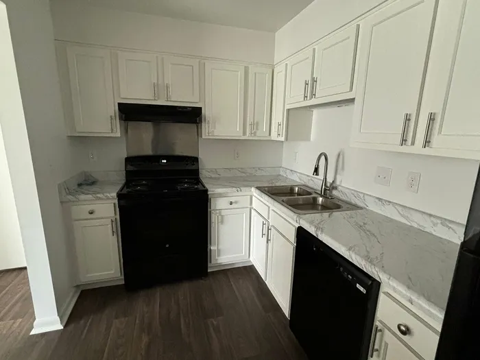 Modern kitchen with sleek white cabinets, elegant marble countertops, and stylish appliances.