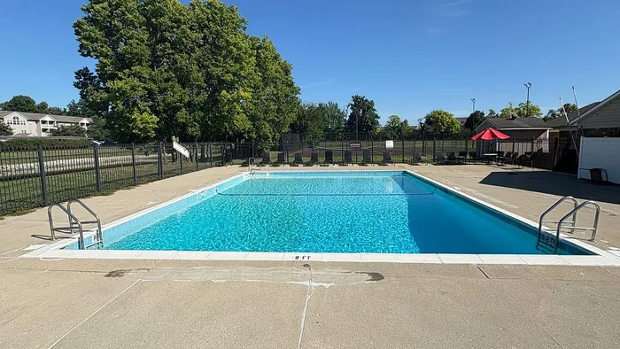 Inviting outdoor swimming pool surrounded by lush greenery and comfortable seating, perfect for relaxation and recreation.