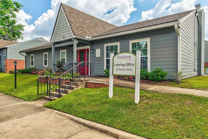 Charming leasing office with inviting red doors and manicured landscaping at Fieldcrest, 31 Trillium Circle.