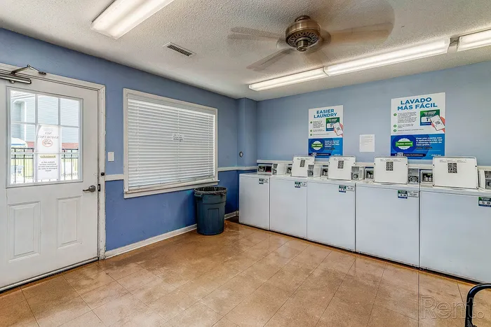 Inviting on-site laundry room with modern washing machines, bright lighting, and convenient amenities for a seamless laundry experience.