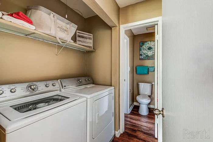 Charming apartment features a convenient in-unit laundry area with modern washer and dryer adjacent to a cozy, well-appointed bathroom.