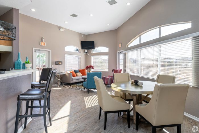 Bright and inviting lounge area featuring modern decor, natural light streaming through large windows, and a comfortable seating arrangement with elegant furniture.