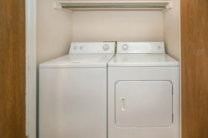 Efficient laundry space featuring modern washer and dryer units in a cozy closet setting.