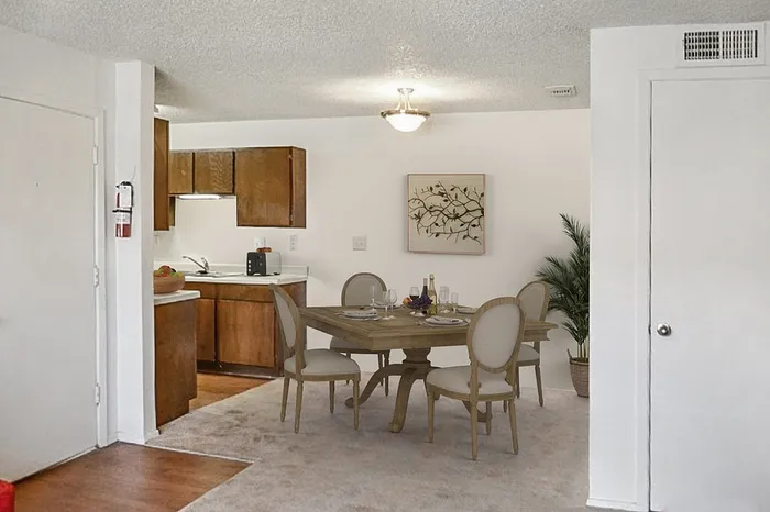 Charming open-plan dining area with elegant wooden furniture, adjacent to a cozy kitchen with warm cabinetry.