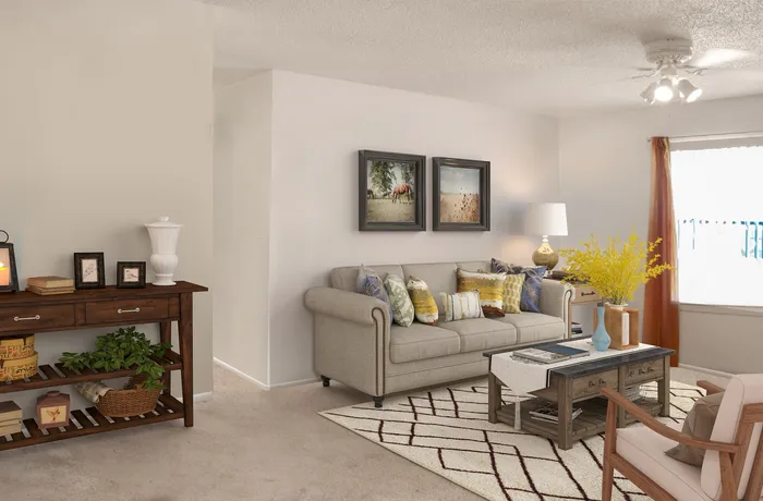 Inviting living room with elegant decor, plush sofa adorned with colorful cushions, stylish coffee table, and artfully curated wall art.