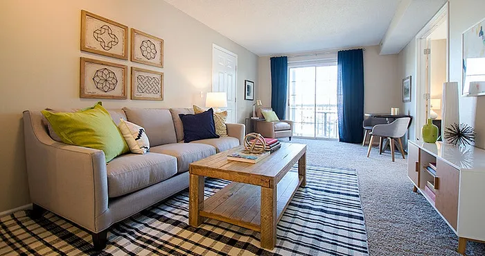 Inviting living room with modern decor, comfortable seating, and natural light streaming through large windows, perfect for relaxation.