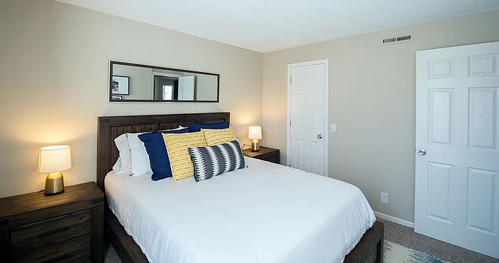 Inviting bedroom with cozy lighting, plush pillows, and elegant wooden furnishings.