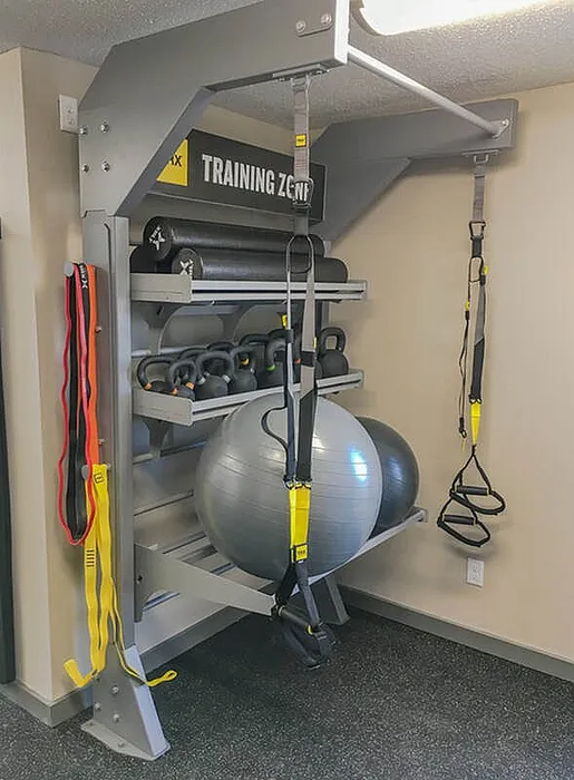 Inviting fitness training zone featuring TRX straps, kettlebells, exercise balls, and resistance bands for a diverse workout experience.