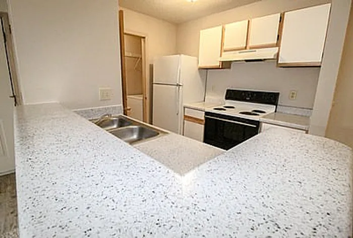 Modern kitchen with sleek countertops, ample cabinetry, and a cozy breakfast bar.