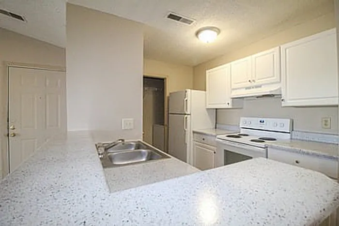 Bright and inviting kitchen with modern white cabinetry, sleek countertops, and a convenient breakfast bar.