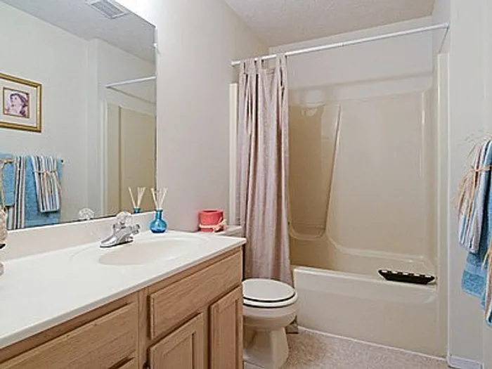Inviting bathroom featuring a sleek bathtub, soft blue towels, and modern decor accents.