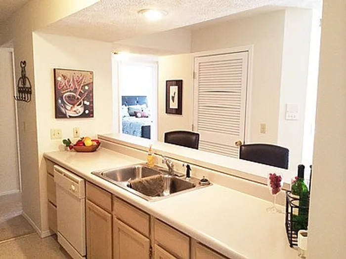 Bright and inviting kitchen with sleek countertops, modern double sink, and cozy dining area with abundant natural light.