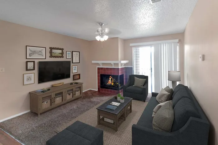 Cozy living room with modern decor, featuring a fireplace, plush gray seating, and a large window offering natural light.