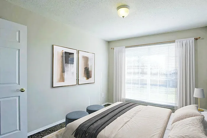 Bright and airy bedroom with large window, elegant decor, and soft lighting for a tranquil living space.
