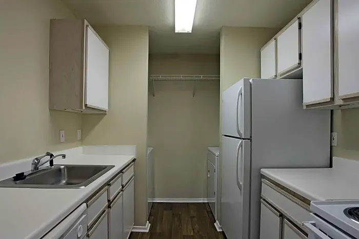 apartment kitchen with wood like floors and white counter tops