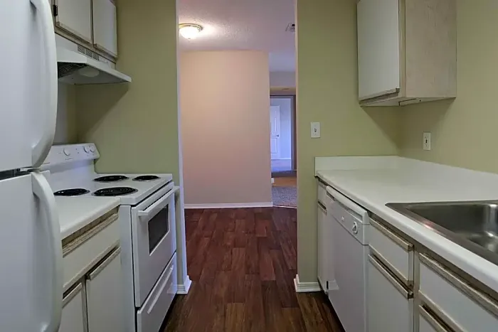 cozy apartment kitchen with wood style flooring and white appliances