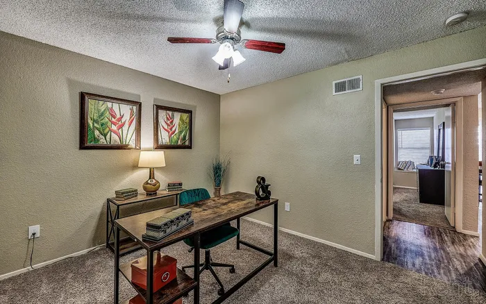 Charming home office with modern decor, featuring a stylish desk, elegant artwork, and warm lighting.