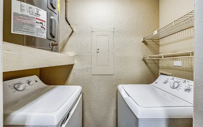 Efficient laundry room boasting modern washer and dryer with ample shelving, perfect for convenient home living.