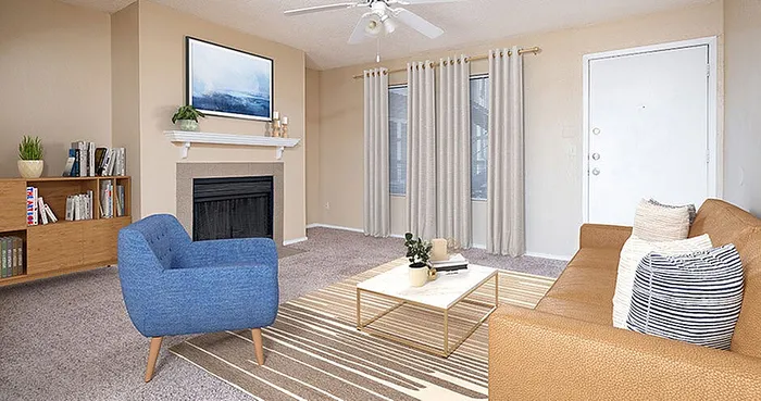 Elegant living room with cozy fireplace, stylish furniture, and natural light from large windows.