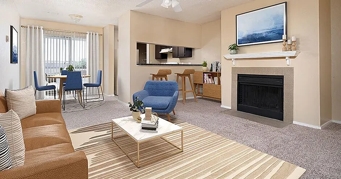 Bright and inviting living room with cozy fireplace, sleek modern furniture, and an open dining area with natural light streaming through large windows.