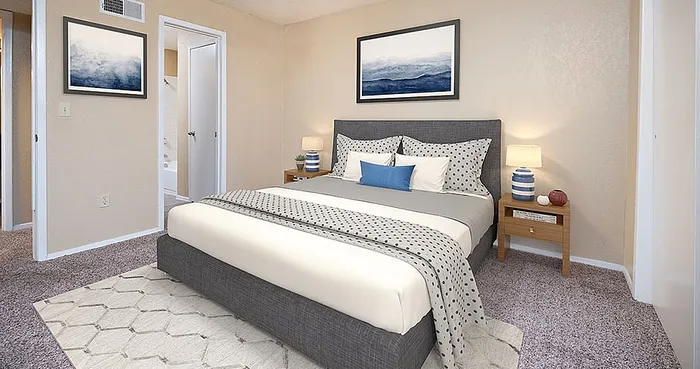Inviting bedroom with plush carpeting, modern décor, and cozy lighting, showcasing a serene and comfortable living space.