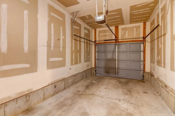 Spacious and clean garage with automatic door, perfect for secure parking or additional storage.