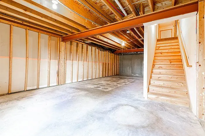 Bright, spacious basement with exposed beams and unfinished walls, perfect for creative renovation opportunities.