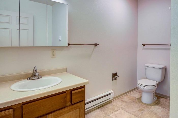Modern and sleek bathroom with elegant fixtures, featuring a large sink vanity and pristine tiling for a refreshing and inviting atmosphere.