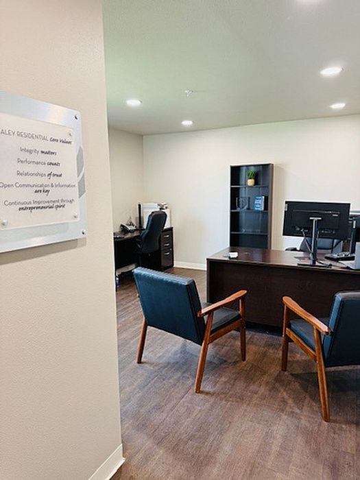 Welcoming home office space with tasteful decor, featuring a sleek desk, comfortable seating, and modern shelving, perfect for productivity.