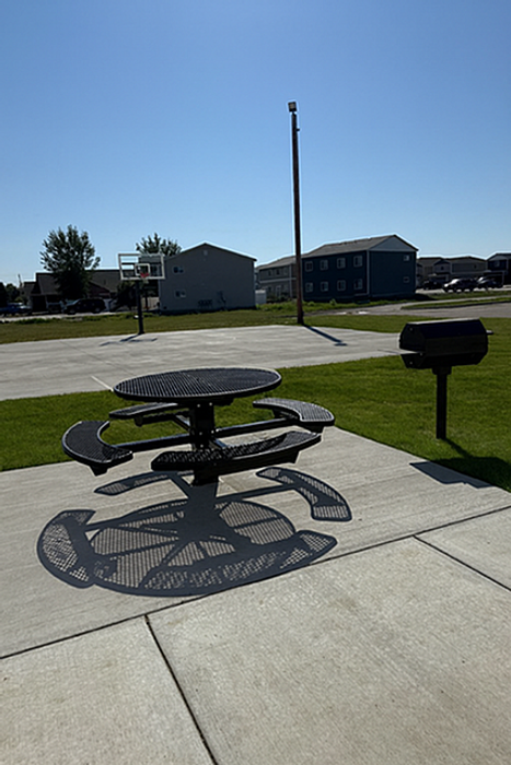 Inviting outdoor space featuring a modern picnic table on a sunny patio, perfect for relaxation and gatherings.