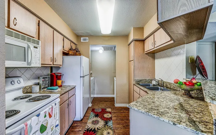 Inviting kitchen with granite countertops, sleek appliances, and stylish wood cabinetry, perfect for culinary creativity.