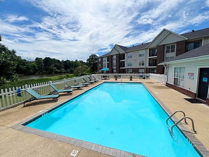 Inviting outdoor pool area with lounging chairs, clear blue water, and scenic views, perfect for relaxation and leisure.