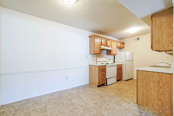 Bright and charming kitchen with sleek appliances and warm wooden cabinetry, perfect for culinary enthusiasts.