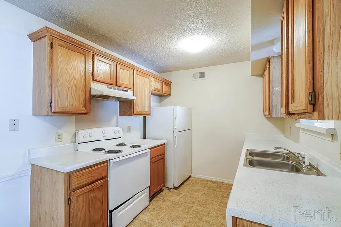 Bright, airy kitchen with modern white appliances, elegant wooden cabinetry, and spacious countertops perfect for culinary creativity.