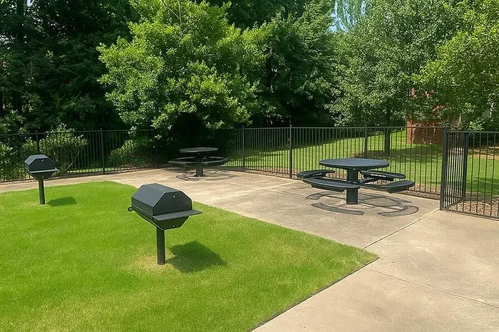 Inviting outdoor area with modern BBQ grills, picnic tables, and lush green surroundings, perfect for gatherings and relaxation.