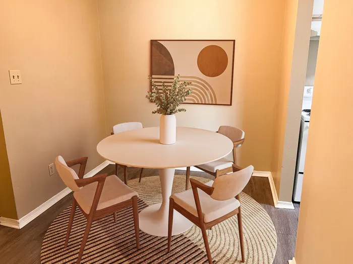 Chic dining area with modern round table, elegant chairs, and stylish wall art, perfect for intimate gatherings.